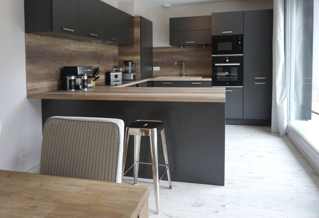 photo appartement VEFA - cuisine gris anthracite, crédence bois, sol bois blanchi